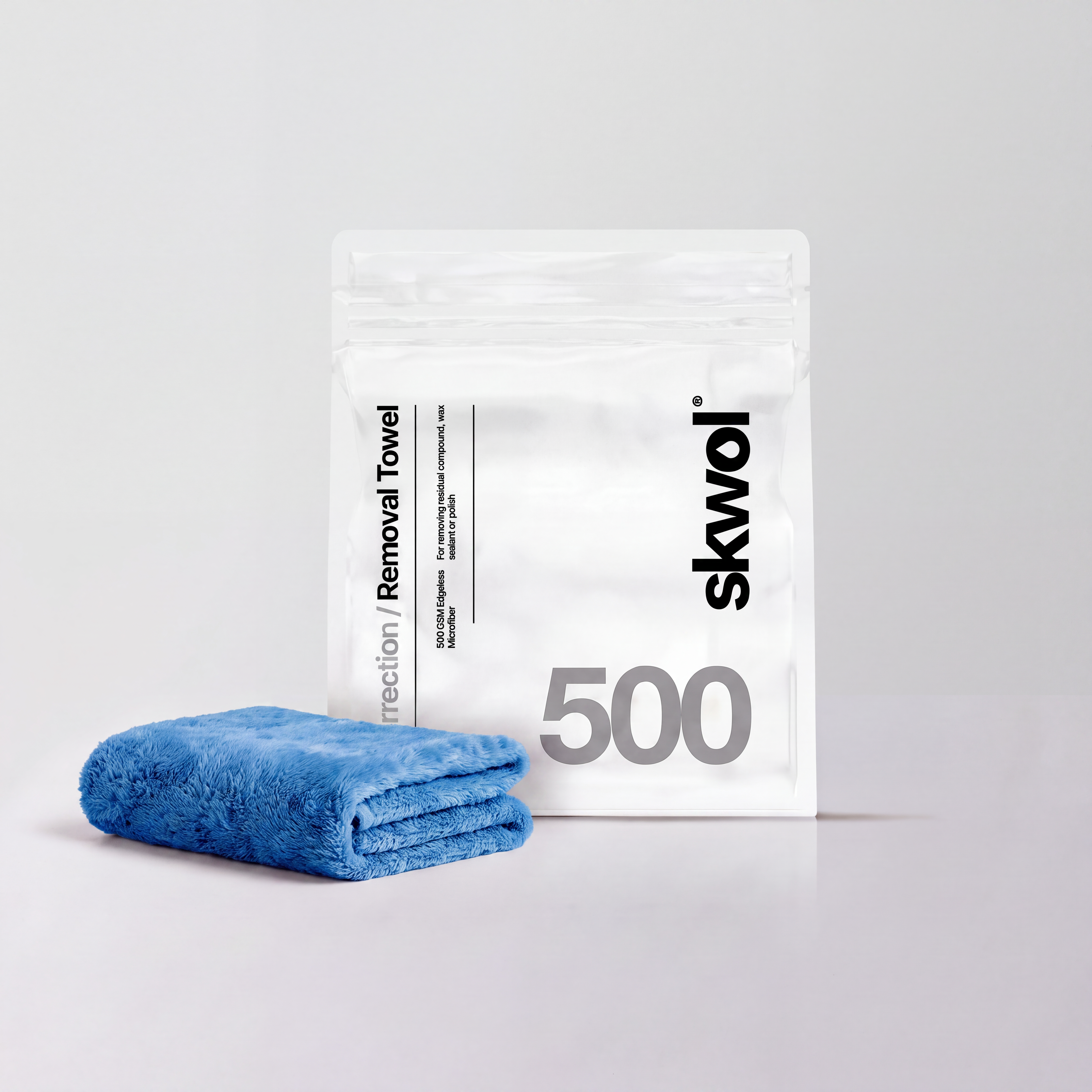 Blue folded fabric towel next to a white skwol Removal Towel bag printed with 500 GSM Edgeless Microfiber.